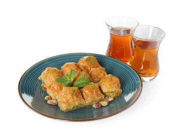 Fıstıklı enfes baklava ve beyaz arka planda sıcak çay.