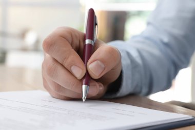 Ofiste kontrat imzalayan adam, yakın plan.