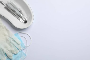Farklı dişçi aletleri, yüz maskeleri ve arka planda eldivenler, düz yatış. Metin için boşluk
