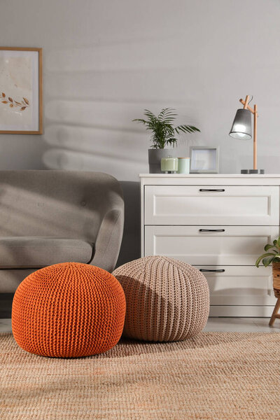 Stylish knitted poufs and sofa in living room. Home design