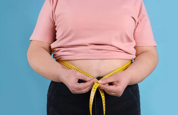 Overweight Woman Measuring Waist Tape Light Blue Background Closeup — Stock Photo, Image
