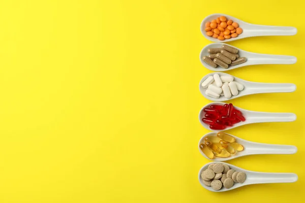 Cucchiai Con Diversi Integratori Alimentari Sfondo Giallo Posa Piatta Spazio — Foto Stock