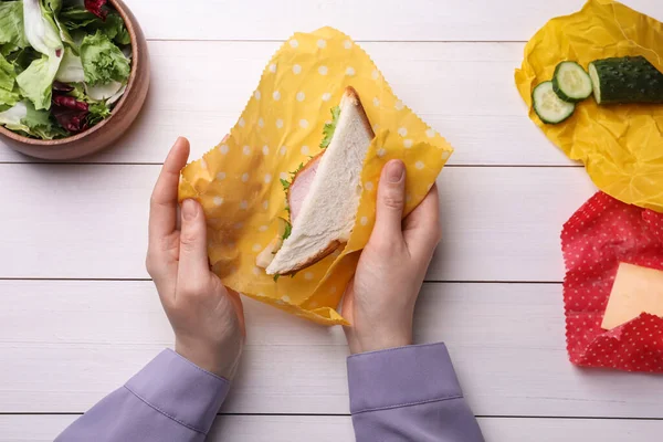 Vrouw Verpakt Sandwich Bijenwas Voedsel Wrap Aan Witte Houten Tafel — Stockfoto