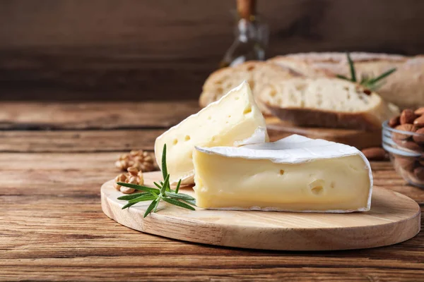 Saboroso Queijo Brie Cortado Com Alecrim Noz Mesa Madeira Espaço — Fotografia de Stock