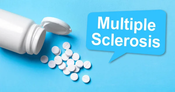 Multiple sclerosis treatment. Pills and bottle on light blue background, above view