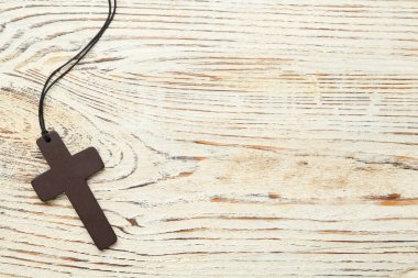 Beyaz ahşap masada Hristiyan haçı, üst manzara. Metin için boşluk