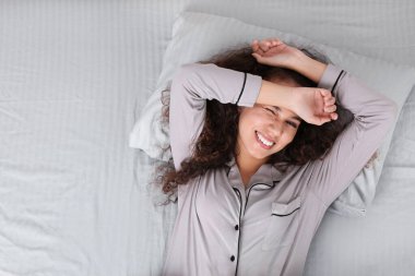 Güzel Afro-Amerikan kadın yatakta yatıyor.