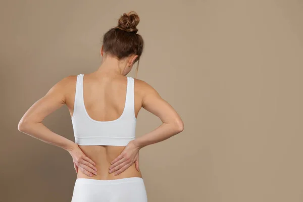 Mujer Que Sufre Dolor Espalda Sobre Fondo Beige Espacio Para —  Fotos de Stock
