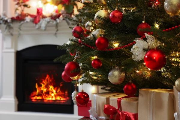 室内壁炉附近美丽的圣诞树和礼物 — 图库照片
