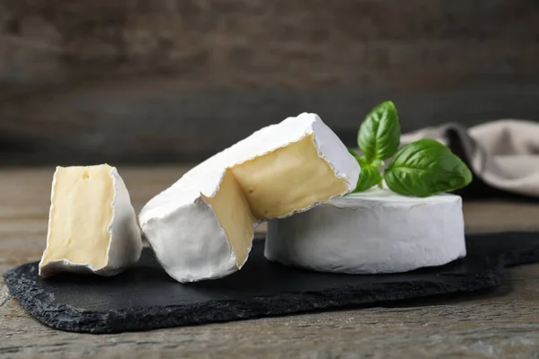 Saboroso Corte Queijo Brie Inteiro Com Manjericão Mesa Madeira — Fotografia de Stock