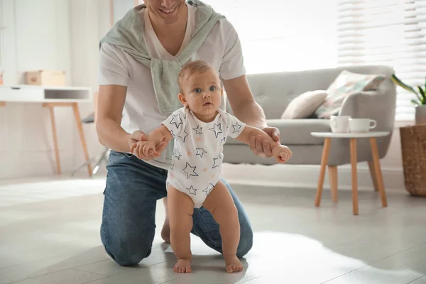 Padre Apoyando Hija Mientras Ella Aprende Caminar Casa —  Fotos de Stock