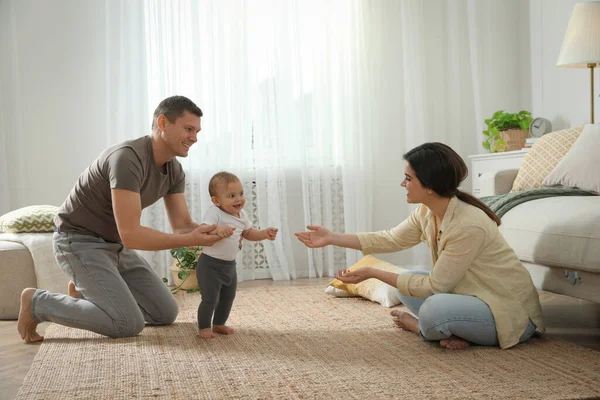 Parents Supporting Baby Daughter While She Learning Walk Home — Stock Photo, Image