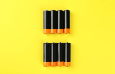 Sarı zemin üzerinde yeni AA piller, düz yatıyordu