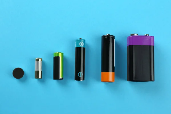 Verschiedene Arten Von Batterien Auf Türkisfarbenem Hintergrund Flache Verlegung — Stockfoto