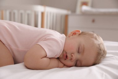 Sevimli küçük bebek evde yatakta uyuyor.