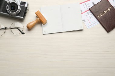 Pasaportlu düz kompozisyon, pul ve uçuş biletleri ahşap masa üzerinde, metin için boşluk