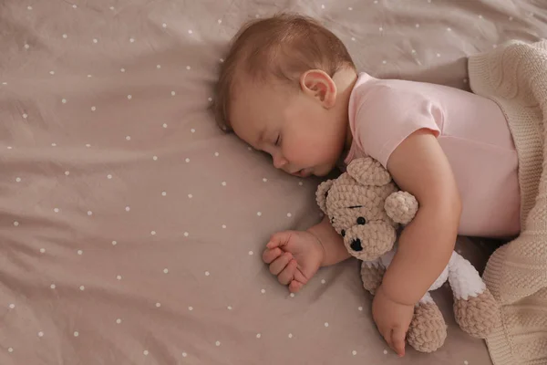 可爱的小宝宝和玩具熊睡在床上 俯瞰上方 案文的篇幅 — 图库照片