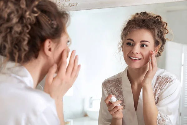 Bella Donna Che Applica Crema Idratante Vicino Allo Specchio Bagno — Foto Stock