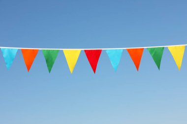 Mavi gökyüzünde renkli üçgen bayraklar