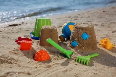 Plastik plaj oyuncakları sahile yakın kumda. Açık hava oyunu