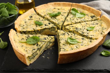 Tahta tabakta lezzetli ıspanaklı turta kes, yakın plan.