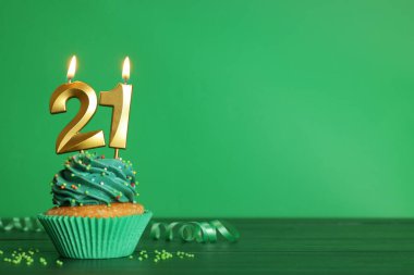 Reşit olma partisi - 21. yaş günü. Yeşil ahşap masa üzerinde numara şekilli mumları olan lezzetli kek, metin için yer var.