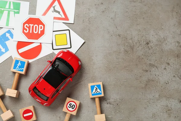 Muitos Sinais Estrada Diferentes Carro Brinquedo Fundo Cinza Flat Lay — Fotografia de Stock