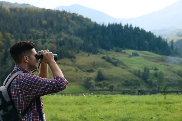 Homem Com Mochila Olhando Através Binóculos Nas Montanhas — Fotografia de Stock