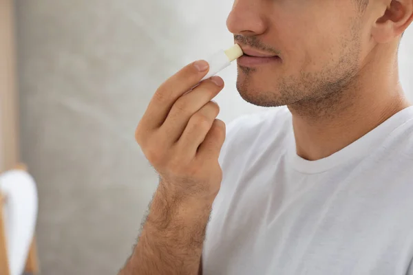 衛生的な唇のバームを屋内で適用する男 クローズアップ — ストック写真