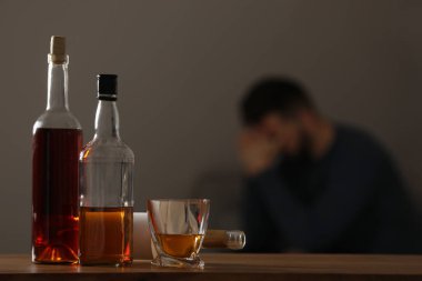 Evdeki bağımlı adam, alkollü içeceklerle masaya odaklan. Metin için boşluk
