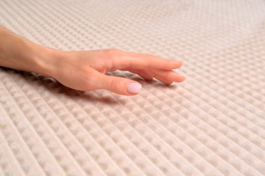 Yumuşak bej kumaşa dokunan kadın, yakın çekim görüntüsü