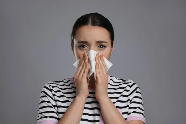 Young Woman Blowing Nose Tissue Grey Background Cold Symptoms — Stock Photo, Image