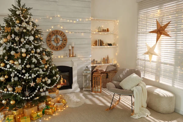 ギフト ボックスとスタイリッシュなリビング ルームのインテリアの暖炉のそばで飾られたクリスマス ツリー — ストック写真