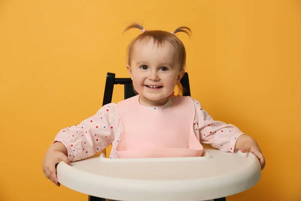 Sarı Arka Planda Sandalyede Önlük Giyen Şirin Bir Bebek — Stok fotoğraf