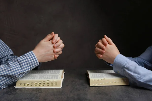 Ζευγάρι Προσεύχεται Πάνω Από Βίβλους Γκρι Τραπέζι Closeup — Φωτογραφία Αρχείου