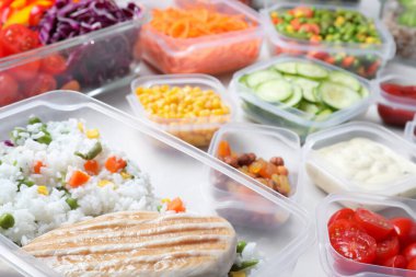 Beyaz masa üzerinde taze yiyecek olan kaplar, yakın plan.