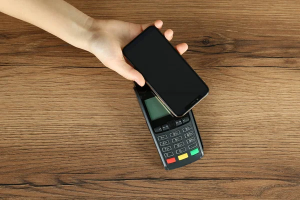 Mujer Con Teléfono Inteligente Con Terminal Pago Moderno Mesa Madera — Foto de Stock