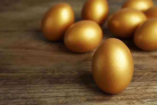 Πολλά Χρυσά Αυγά Ξύλινο Τραπέζι Κοντινό Χώρος Για Κείμενο — Φωτογραφία Αρχείου