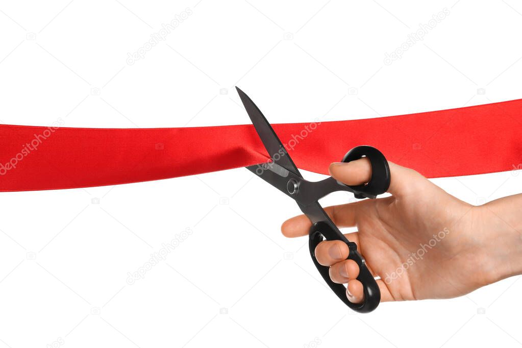 Man cutting red ribbon on white background, closeup