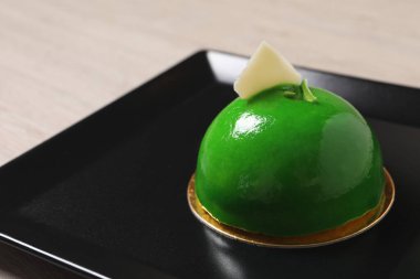 Tabakta beyaz çikolatayla süslenmiş lezzetli bir tatlı, yakın plan. Metin için boşluk