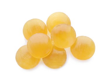 Beyaz arka planda birçok sarı öksürük pastili, üst görünüm