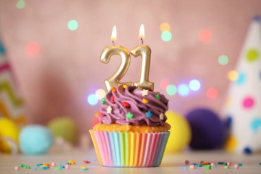 21. yaş günü. Beyaz masadaki reşit olma partisi için numara şekilli mumları olan enfes kek.