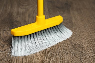 Plastik süpürge ile ahşap zemin süpürüp, yakın plan
