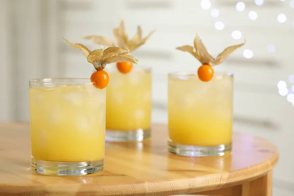 Cocktail Rinfrescanti Decorati Con Frutta Physalis Tavolo Legno Contro Luci — Foto Stock