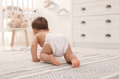 Evde yerde sürünen tatlı bir bebek, arka manzara.