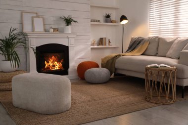 Odadaki kanepenin yanında şık, rahat puf. Ev tasarımı