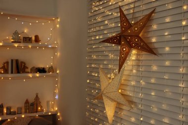 Güzel dekoratif yıldızlar ve odadaki şenlikli ışıklar. Noel atmosferi