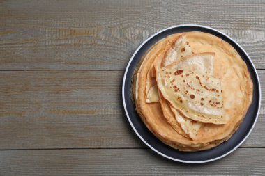 Gri ahşap masadaki leziz krep yığını, üst manzara. Metin için boşluk