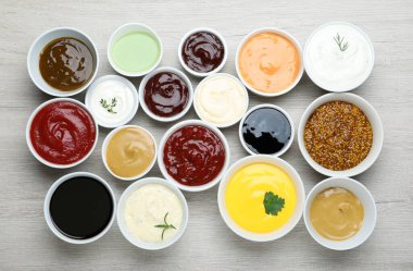 Beyaz ahşap masa üzerinde bir sürü farklı sos, düz yatıyordu.