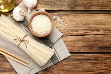 Ahşap masada pişmemiş pirinç eriştesi, düz. Metin için boşluk